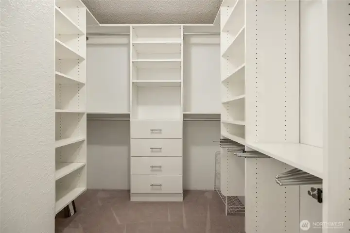 Primary walk in closet with built in organizers.
