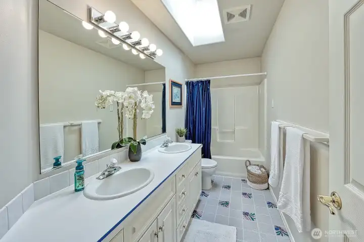 Full bath with double sinks on middle level.