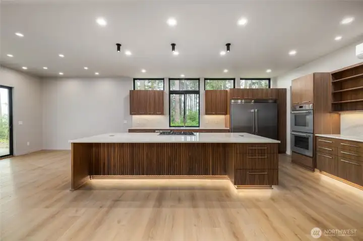 Sneak peek!  Dream kitchen with expansive center island, full-sized fridge and freezer, Taj Mahal quartz counters and backsplash.  Double ovens and gas stovetop.