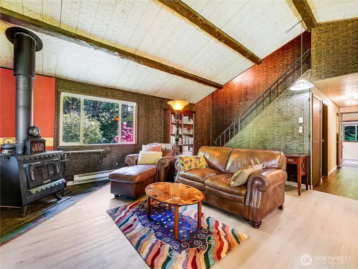 Living room with wonderful wood stove, new flooring and stairs which lead up to a loft bedroom Living room with wonderful wood stove, new flooring and stairs which lead up to a loft bedroom