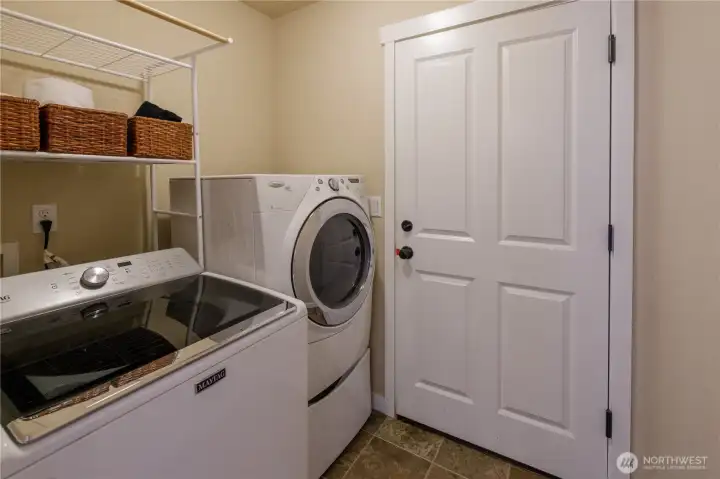 Conveniently located utility room, washer and dryer stay with the home.