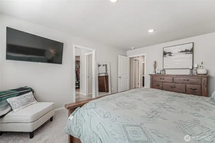 Primary bedroom opens into en suite and walk-in closet.
