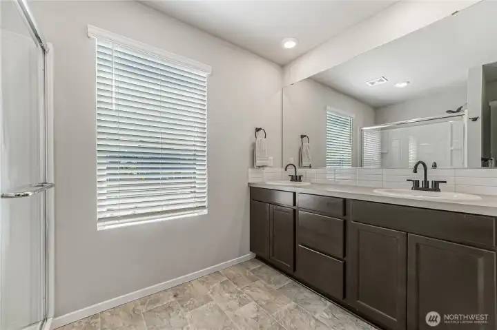 Primary bath features an oversized walk-in shower and double sinks.