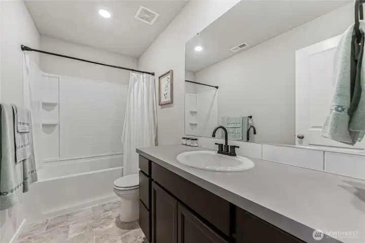 Main bath upstairs features ample counter and cabinet space.