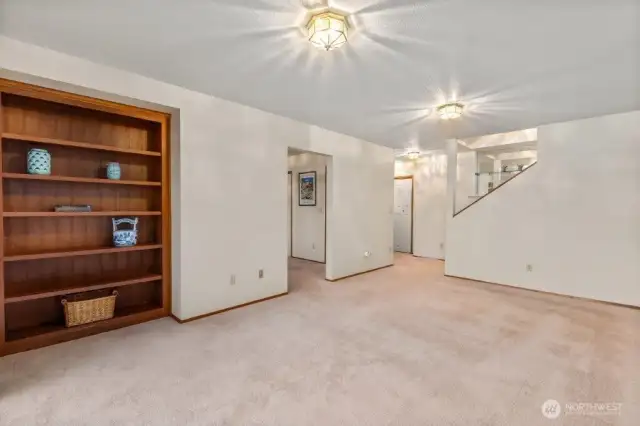 Moving downstairs, this is the family room with built in shelves. Through the opening on the left is the 4th bedroom or den/office space, adjacent to a full bathroom.