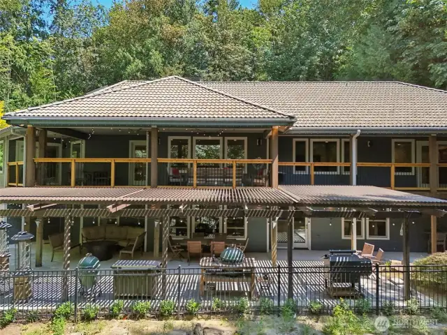Enjoy nature on both a top balcony that expands the entire first floor AND a curated lower patio. Let the light in or keep dry with the louvred awning on the lower patio