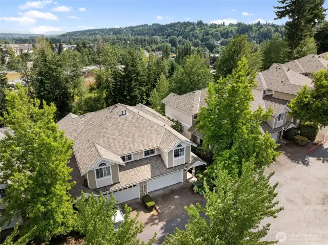 Aerial view captures the home’s setting, surrounding greenery, and peaceful community feel.