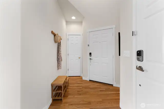 Thoughtfully designed entry with access to the garage, a convenient storage closet, and a welcoming front door—all grounded by classic wood flooring.