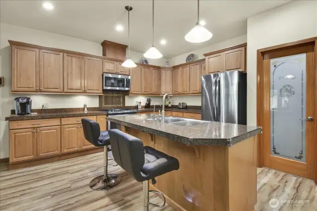 kitchen that boasts New Stainless Steel Appliances, walk in pantry, abundant cabinet storage, tons of counter space, and Large Island with room for bar stools