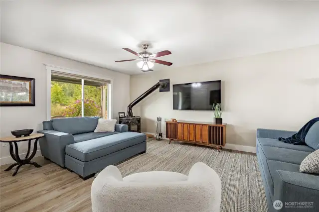 Lovely living room features woodstove and open to dining room.