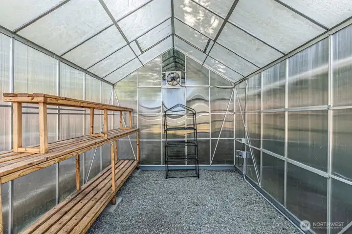 Gardner’s dream a 8x10 greenhouse with power, wood shelves and thermostat-controlled exhaust fan.