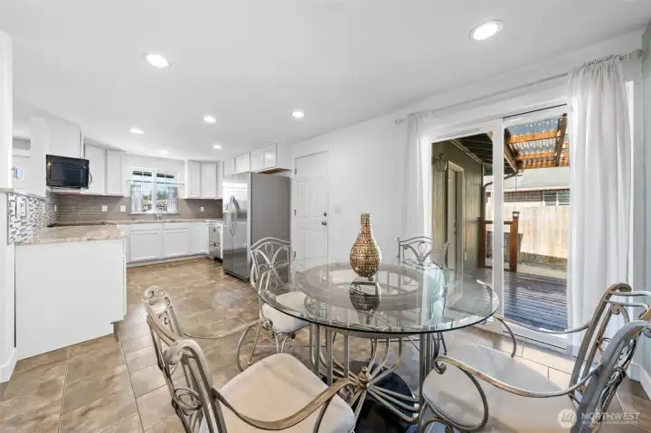 Dining room with recessed lighting, window and tile floors.