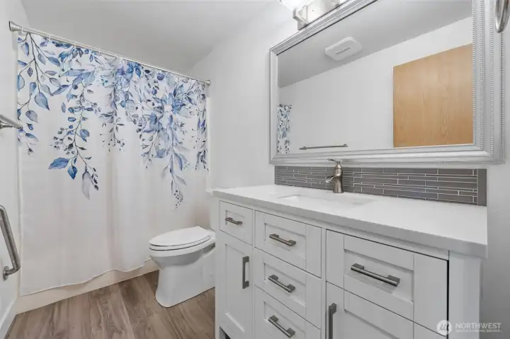 Full bathroom with large mirror, white vanity with plenty of drawers and cabinets.