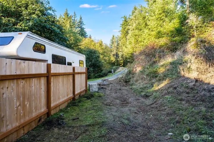 Driveway access to lower level of property. Fenced neighbor on left