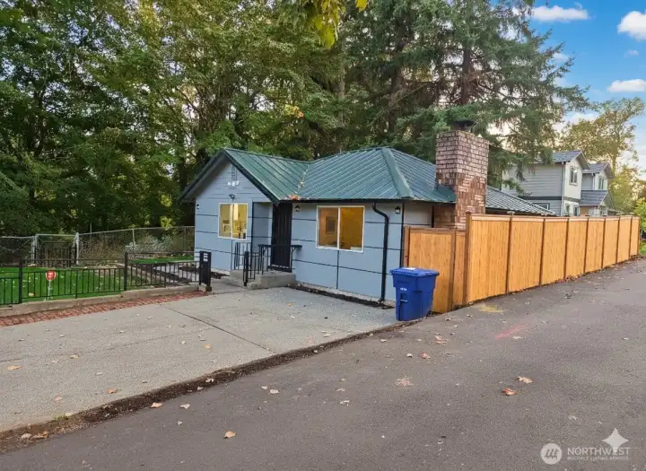 Crisp, clean curb appeal with brand-new HardiePlank siding, modern black trim, and a fresh metal roof. The new fence and paved drive add a polished touch, setting the tone for the quality finishes you'll find throughout this fully renovated Kennydale home.