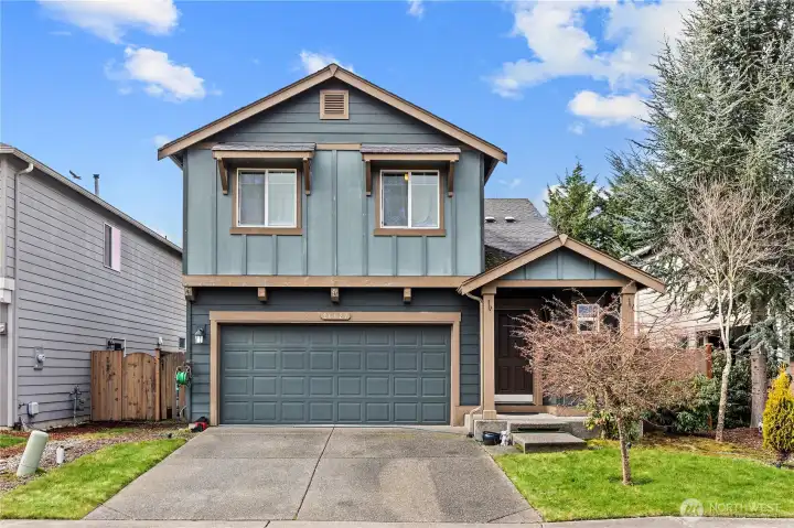 Craftsman-style exterior with covered front porch, clean siding, and excellent curb appeal. Well-maintained home on a quiet residential street with sidewalks and neighborhood charm.