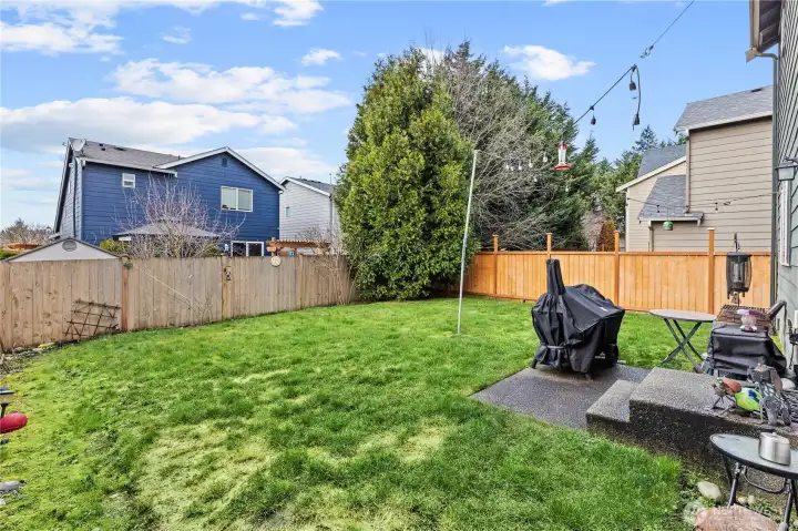 Back patio provides seamless indoor-outdoor flow, perfect for grilling, dining, or enjoying the outdoors in a private, fenced setting.