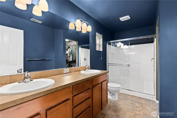 Primary bath features dual sinks, ample counter space, and clean finishes. Walk-in shower provides function and comfort in the private primary bathroom.