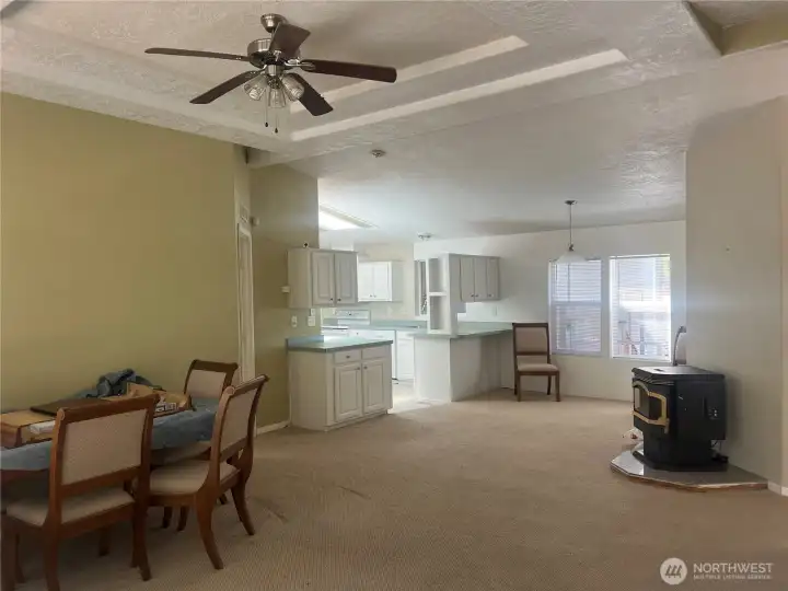 Living room open to kitchen and dining room with pellet stove.