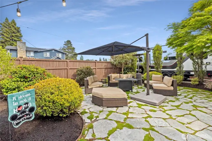 Beautifully designed flagstone patio with fire feature seating area, mature landscaping and inviting outdoor gathering spaces.