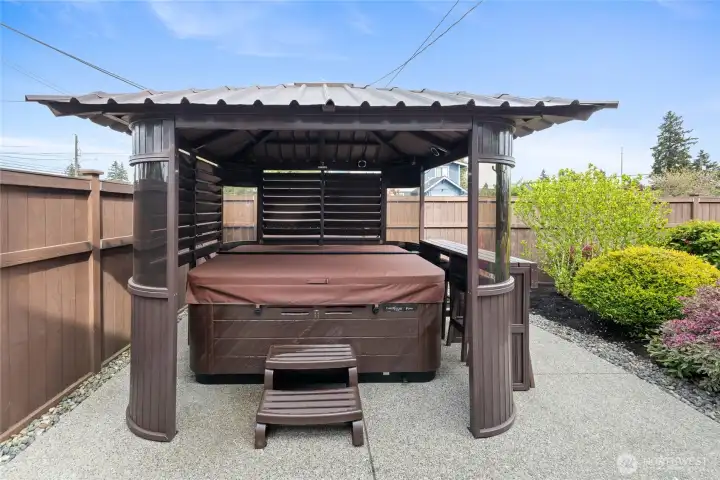 Private covered spa pavilion creates the perfect year-round escape with relaxing hot tub and resort-inspired ambiance.