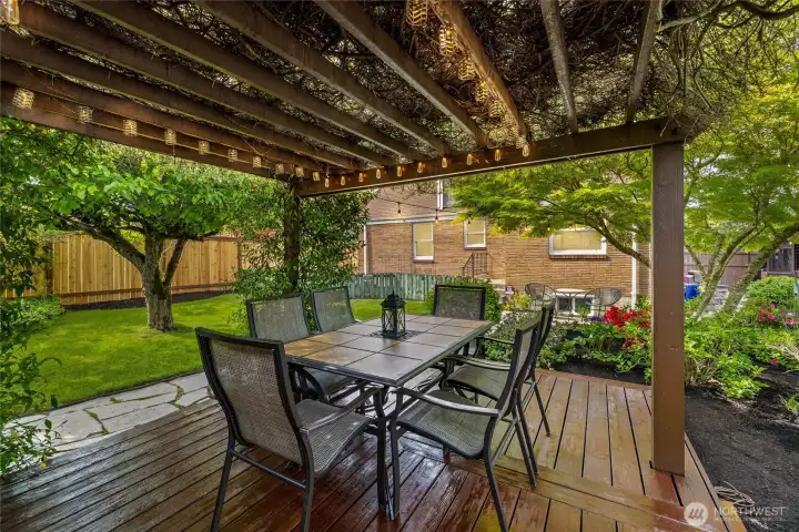 Covered pergola dining area surrounded by mature landscaping offers an ideal setting for outdoor entertaining and relaxing evenings. Draped in Jasmine exudes fragrant blossoms.