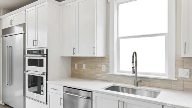 Gorgeous kitchen with tons of space to prepare!  48" counter depth refrigerator, built in microwave & oven + gas cooktop! White cabinets are an upgrade available to add early in construction.