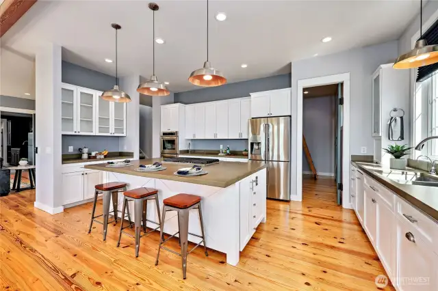 Note the large island with bar seating, endless cabinet and storage space, and the walk in pantry at the rear.