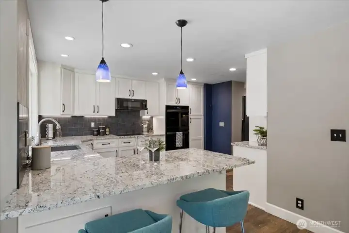 Open kitchen bar area with storage underneath and custom Pendant lighting. Beautiful thick Granite counters throughout!