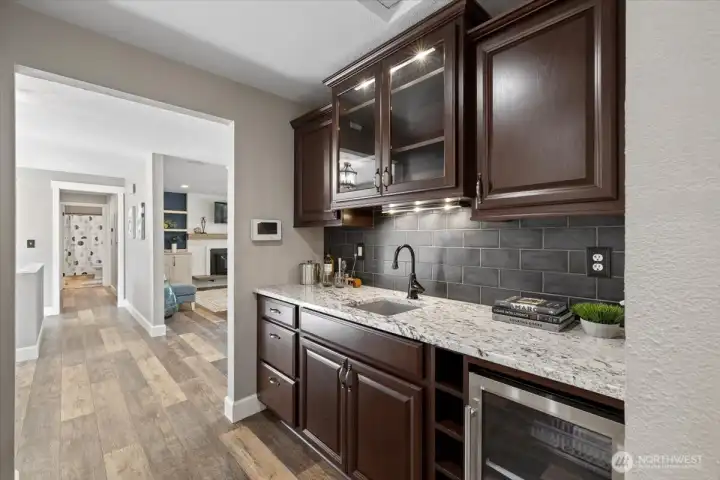 Well designed Butler's pantry with Wine fridge and sink! Plenty of cabinetry and Windowed cabinets to show off that stemware!