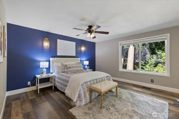 Comfortably spacious main floor Primary bedroom! Plenty of room for any sized bed. Windows looking out to the private backyard and out onto the deck.