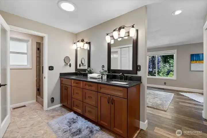The Primary bathroom with dual vanity, granite counters, rich cabinetry, and a new California closet just recently put in across from the vanity.  A few solar tubes are strategically place to add additional light.