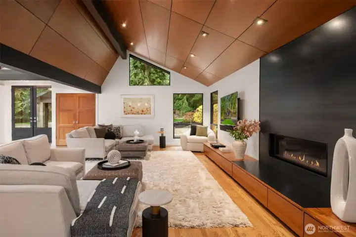 Light filled living space with soaring ceilings and a striking hot-rolled steel  fireplace