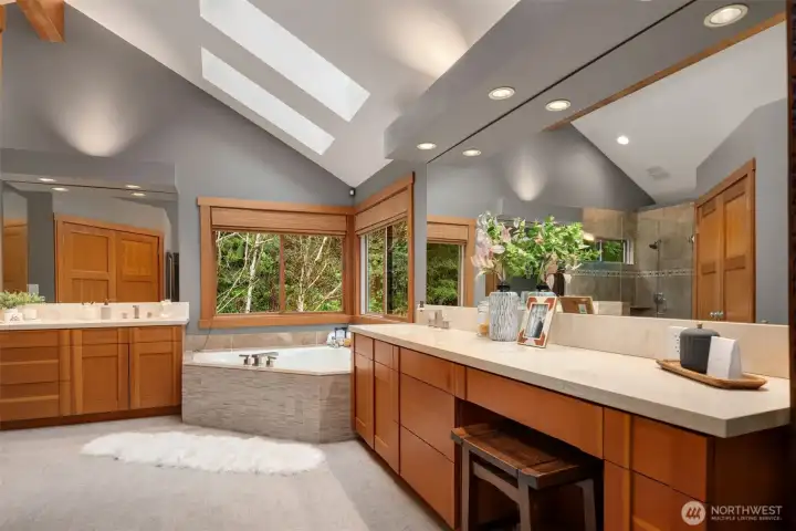 Primary bathroom with fir cabinetry, travertine slab finishes and natural light
