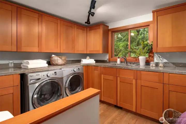 Well appointed laundry room with abundant cabinetry and functional design