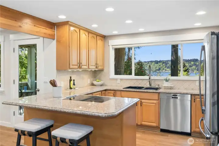 The kitchen has mesmerizing views of Puget Sound and the mature landscaping..
