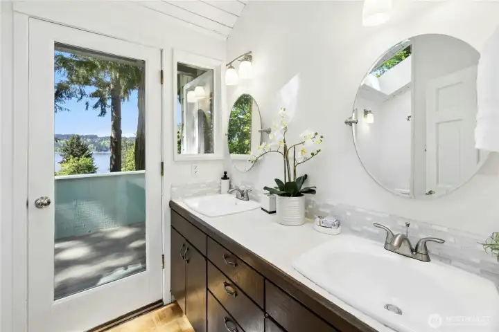 The primary bath has a double sink vanity and a door out to the private deck.