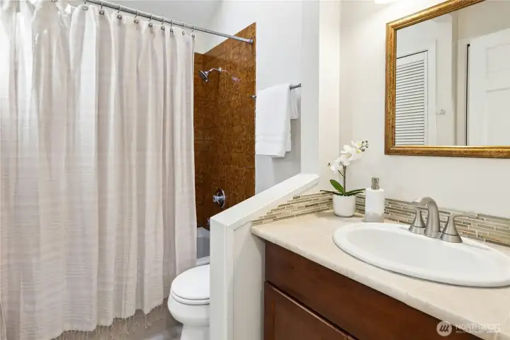 The upstairs hall bath features vintage tile around the bathtub.