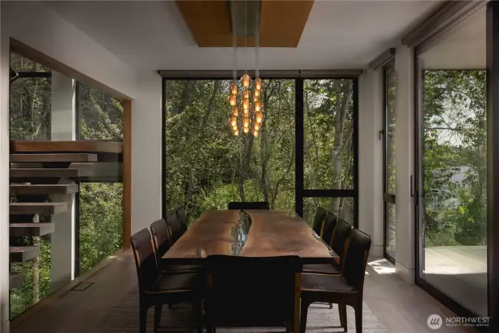 The dining area sits within the landscape, with a view terrace just beyond extending the experience outward.