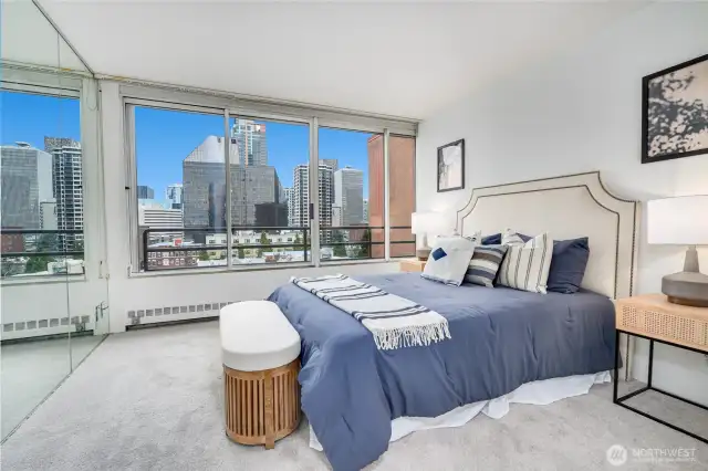Primary bedroom suite, where you can gaze at the city skyline or unwind in luxurious comfort.