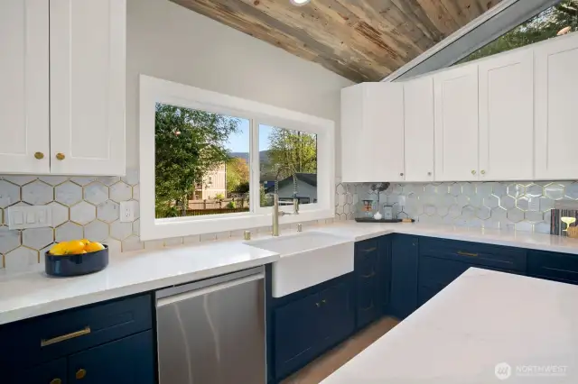Marble backsplash and under cabinetry lighting! All new high end appliances and white shaker cabinetry with soft closing doors. Large window looking out towards the yard