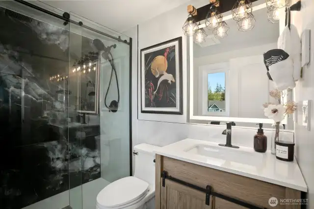 Primary en-suite bathroom with defrosting mirror, and stunning sleek tile creating spa atmosphere