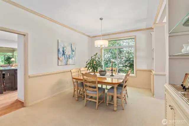The dining room is centrally located between the kitchen and formal living room and features built-in storage and display shelves—perfect for serving pieces, seasonal décor, or your favorite glassware. It's a warm, functional space for everyday meals or special gatherings.