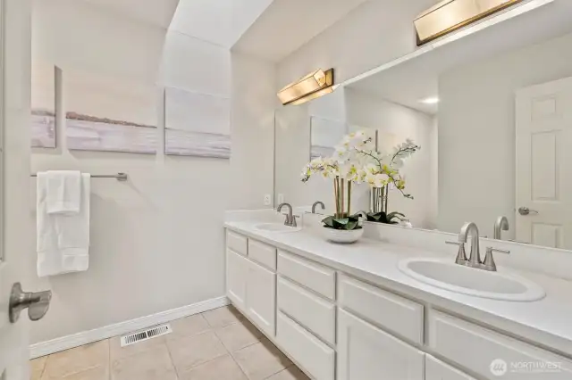 The first hall bathroom features double sinks, generous counter space, and a skylight that fills the room with natural light creating a bright and functional space.
