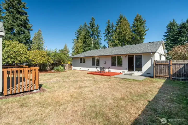 Full fenced backyard has both a patio & deck plus tool shed
