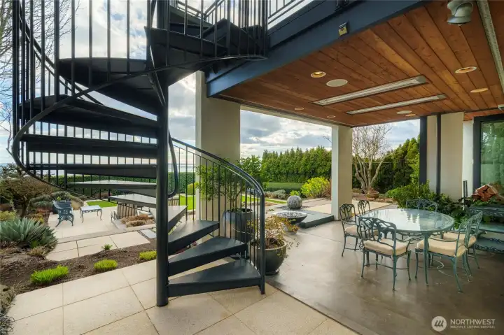 Here is the protected alcove with heat lamps. The pretty fireplace is just in the foreground.  And this spiral staircase descends from the deck outside the dining room.
