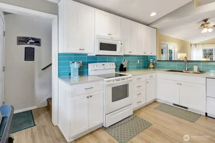 Kitchen with newer quartz counters and glass tile backsplash
