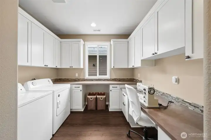 Laundry room with tons of cabinets and counterspace for crafting or extra office space.