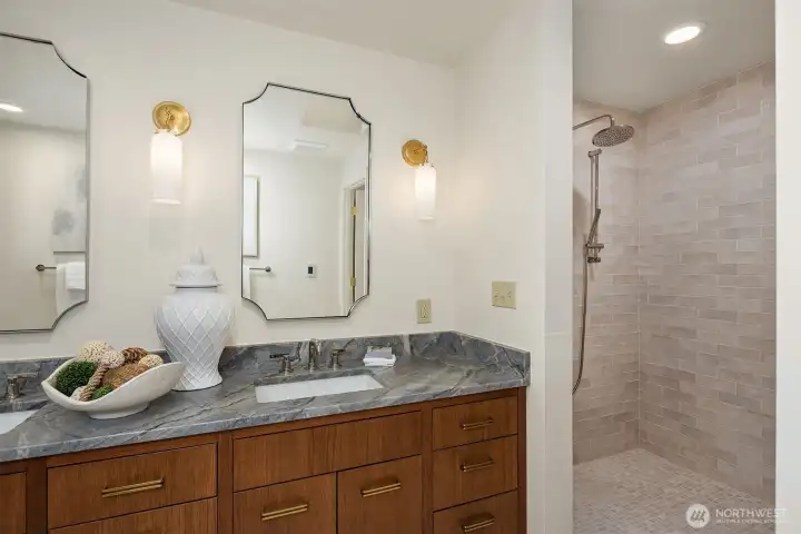 The dreamy walk-in shower is lined with a luxuriously serene tile pattern.