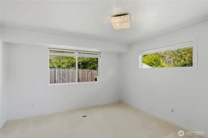 Spacious primary bedroom with large windows and natural light.